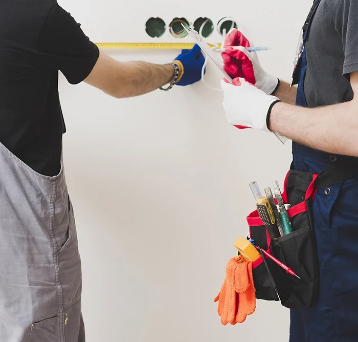 Two drywall professionals measuring and planning wall installation – drywall services Georgina by Express Drywall Services.
