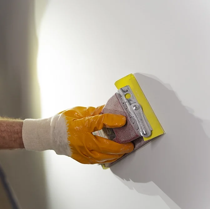 Wall sanding during finishing stage of drywall services Tiny Township by Express Drywall Services.