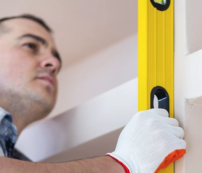 Worker using level tool to ensure drywall precision - professional drywall services Ajax by Express Drywall Services.