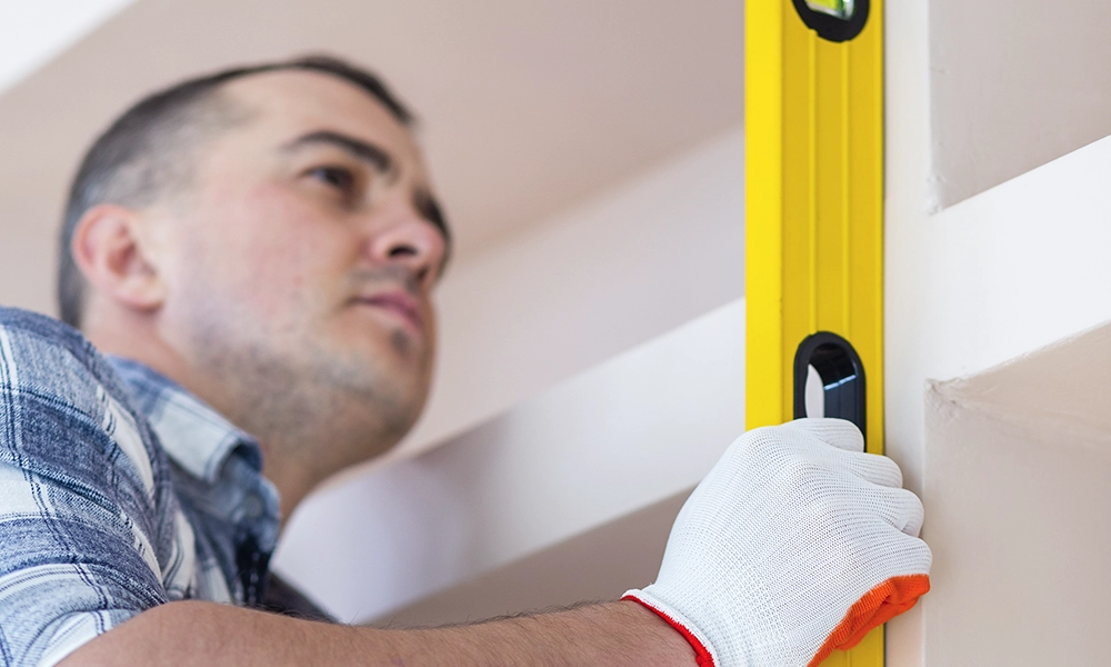 Worker using level tool to ensure drywall precision - professional drywall services Ajax by Express Drywall Services.