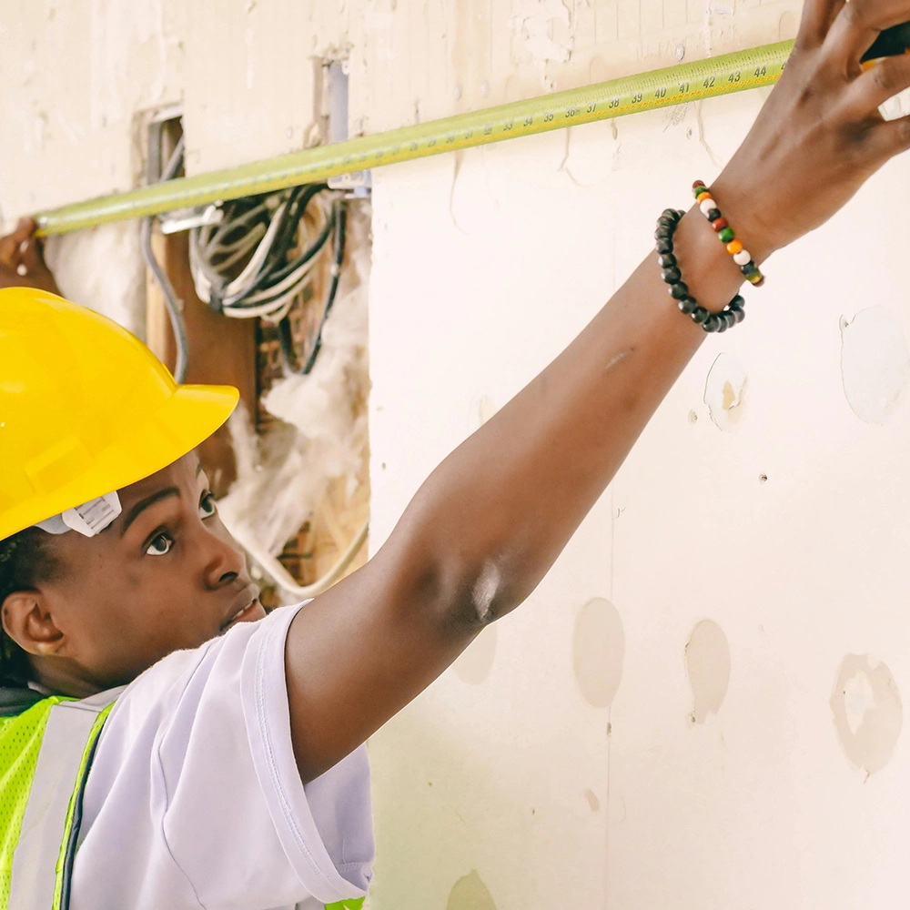 Express Drywall Services technician measures wall space during commercial drywall installation in a retrofit project.