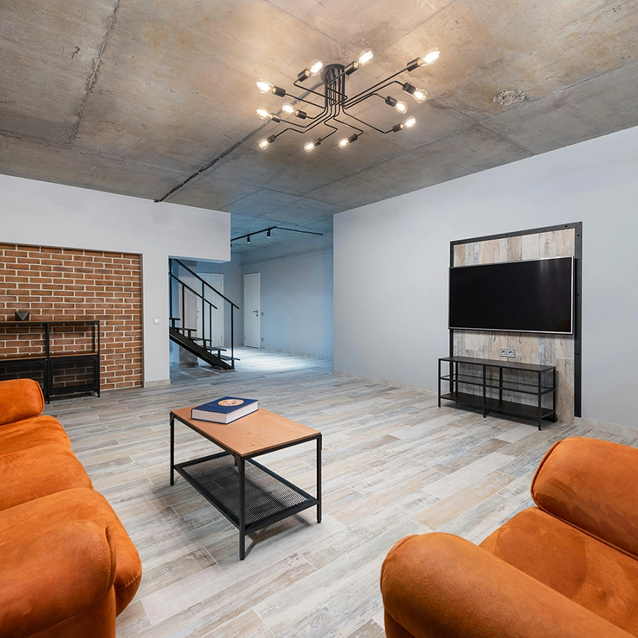 Raw concrete ceiling in a basement living area, a candidate for Express Drywall Services residential texturing services.