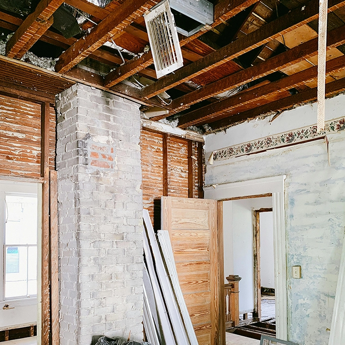 Home renovation project showing exposed brick and lath walls before insulation installation by Express Drywall Services.