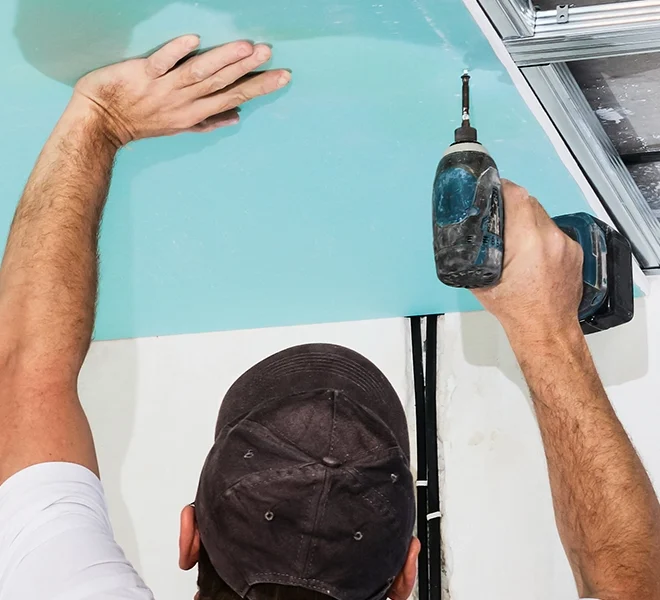 Drywall specialist installing ceiling panel - expert drywall services Oakville by Express Drywall Services.