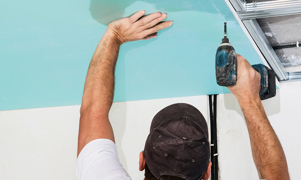 Drywall specialist installing ceiling panel - expert drywall services Oakville by Express Drywall Services.