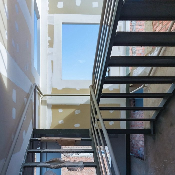 Stairwell area during commercial fire-resistant drywall installation by Express Drywall Services