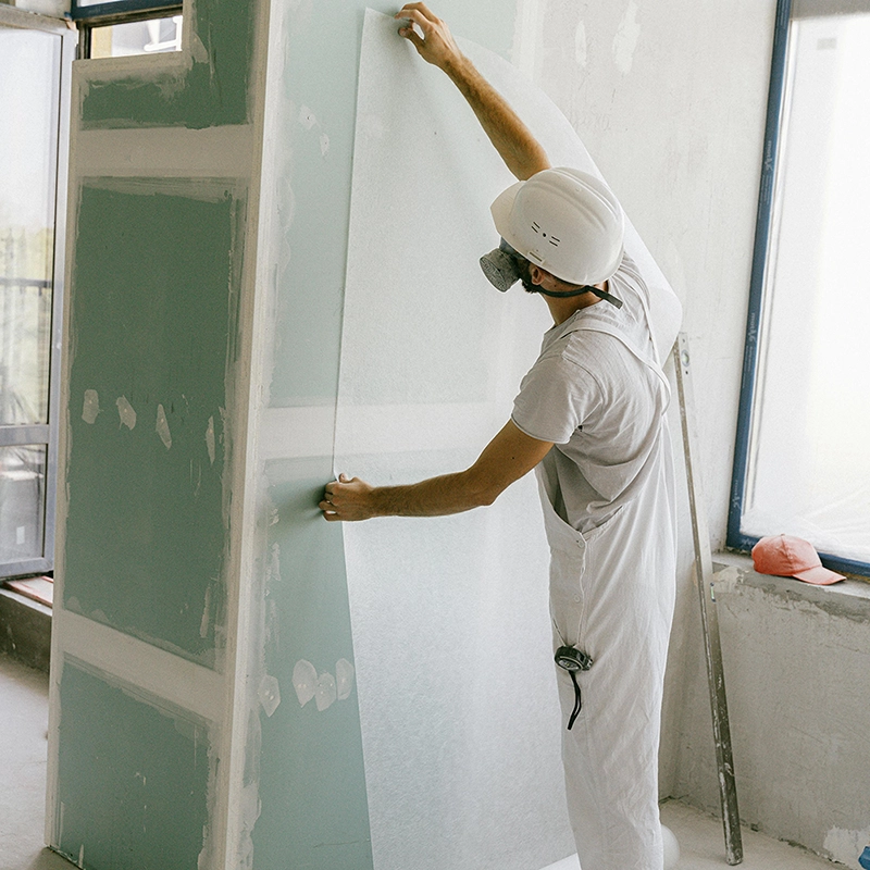 A worker from Express Drywall Services applies fiberglass before drywall taping and mudding to prep the surface properly.