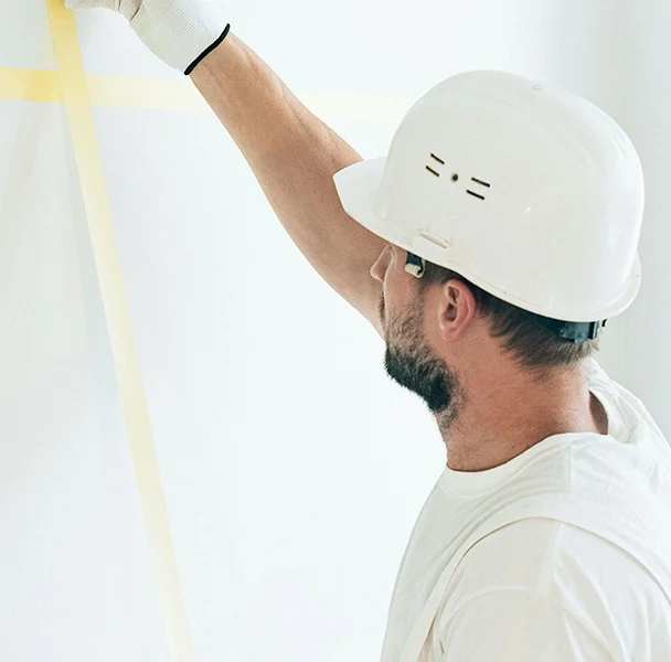 Worker applying masking tape for drywall prep - professional drywall services Whitby by Express Drywall Services.
