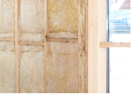 Fiberglass insulation installation in residential wall cavity