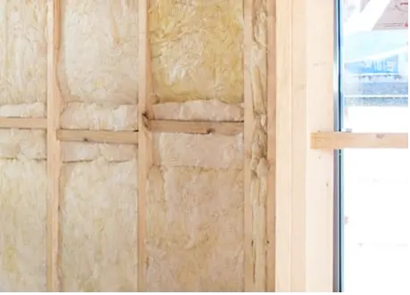 Fiberglass insulation installation in residential wall cavity