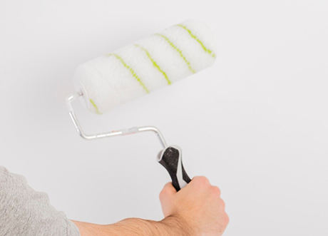 Applying wall primer with roller as part of priming and painting by Express Drywall Services