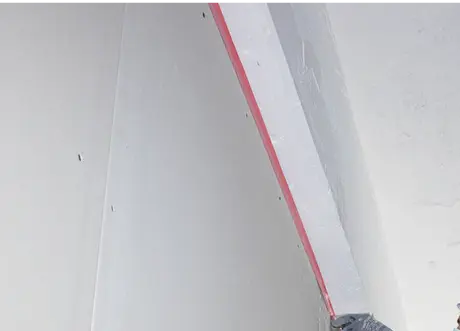 Fire caulking bead applied along a ceiling joint in drywall.