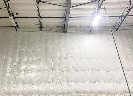 Completed commercial Insulation Installation and stickpin Insulation by Express Drywall Services on high warehouse walls.