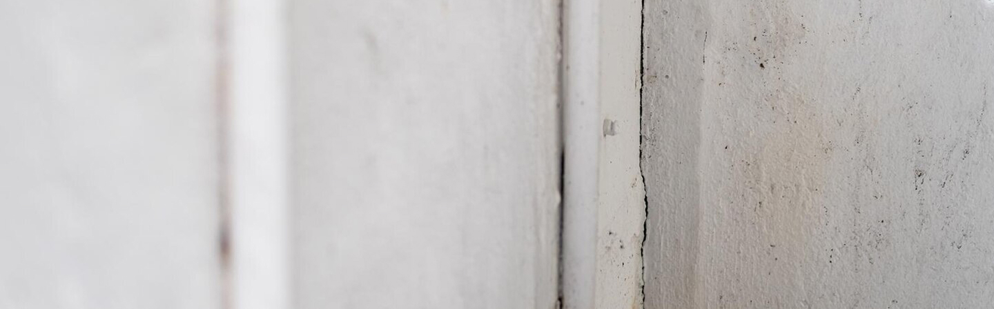 Wall damage and seam separation before drywall repair by Express Drywall Services.