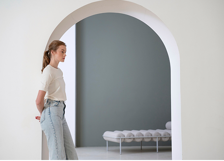 Woman standing near a white interior archway, representing commercial custom archways and designs by Express Drywall Services.
