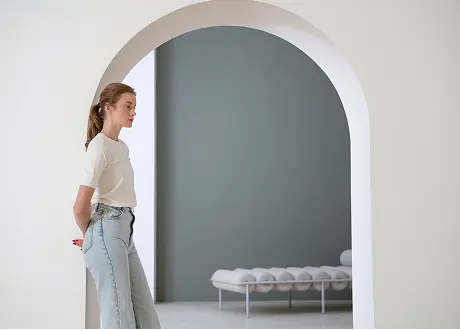 Woman standing near a white interior archway, representing commercial custom archways and designs by Express Drywall Services.