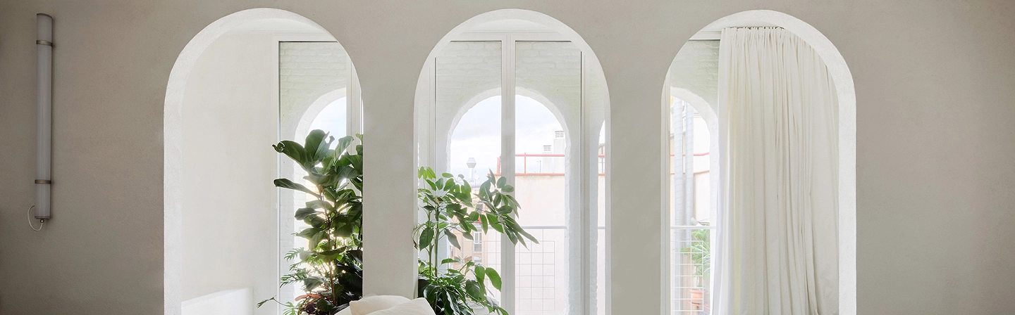 Triple arched windows with white framing showcasing commercial custom archways and designs by Express Drywall Services.