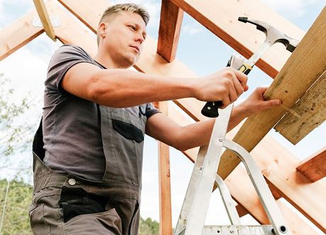 Construction worker installing lumber as part of commercial framing by Express Drywall Services