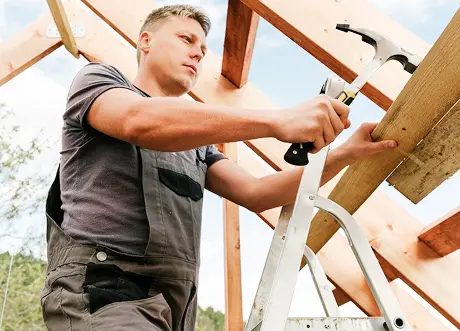 Construction worker installing lumber as part of commercial framing by Express Drywall Services