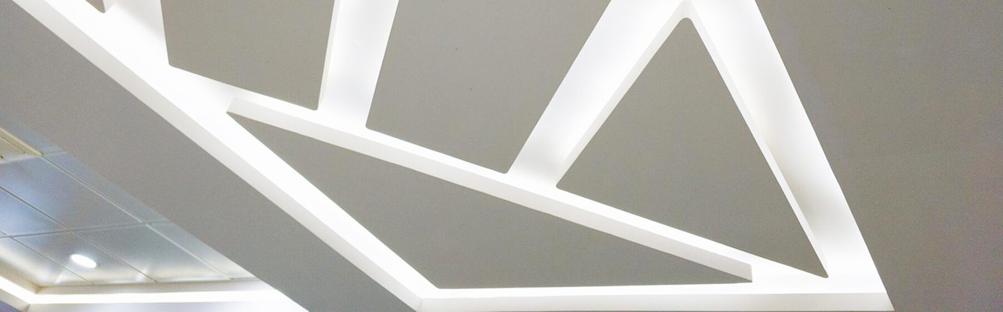 Creative geometric lighting design integrated into a commercial T-Bar and drop ceiling.
