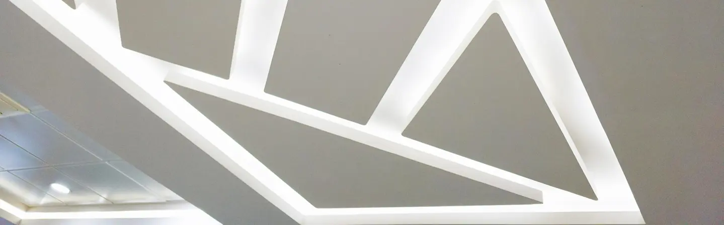 Creative geometric lighting design integrated into a commercial T-Bar and drop ceiling.