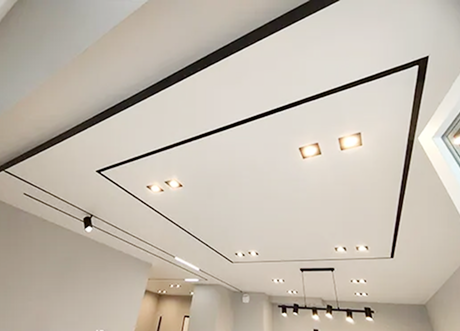 Finished commercial T-Bar and drop ceilings with integrated lighting in an office space.