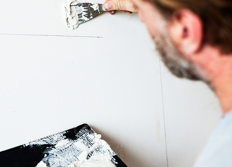 Technician applying compound during drywall repair by Express Drywall Services.