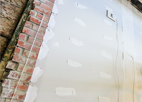 Brick wall prepared with drywall mud for fire and sound separation