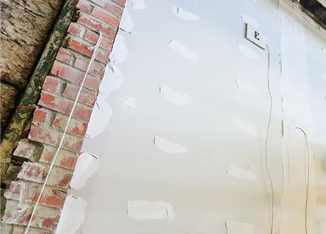 Brick wall prepared with drywall mud for fire and sound separation