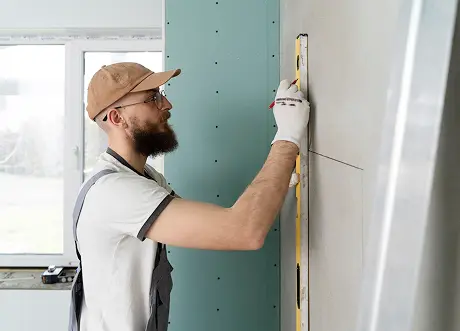 Express Drywall Services technician marking layout lines during residential drywall installation.