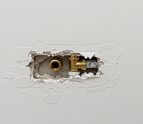 Plumbing access hole made during residential drywall installation by Express Drywall Services.