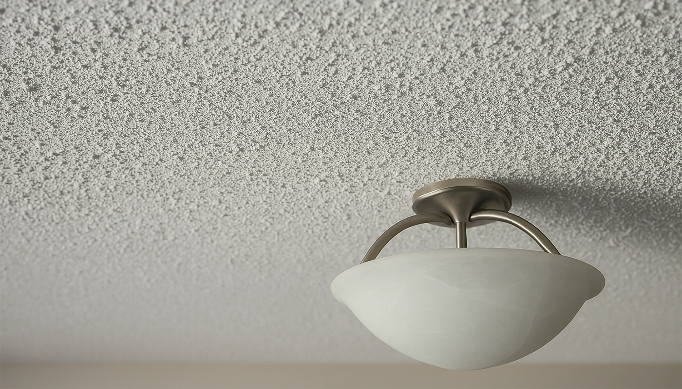 Close-up of ceiling texture around a ceiling light fixture, highlighting popcorn ceiling removal in Toronto by Drywall Express Services.