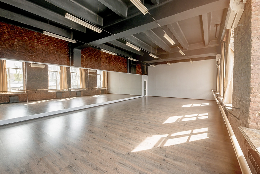Bright open studio with exposed brick and acoustic potential – fire and sound separation in Toronto by Drywall Express Services.