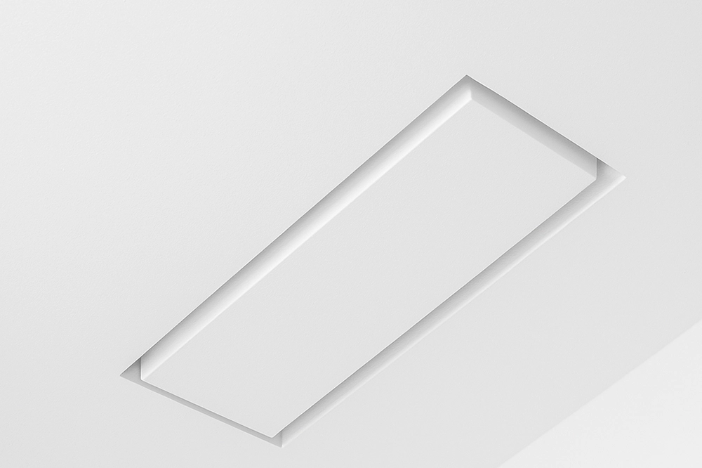Close-up of a minimalist Aria ceiling vent flush-mounted into a smooth white drywall surface.