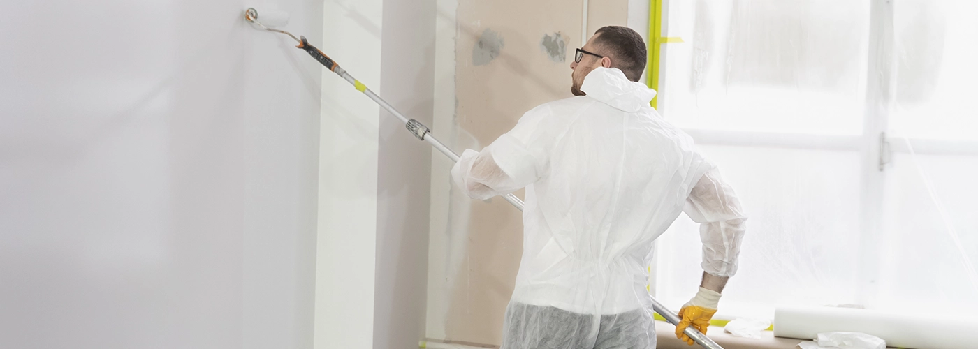 A worker in protective gear painting drywall after repair – Drywall Repair Tips Every Homeowner Should Know by Express Drywall Services 