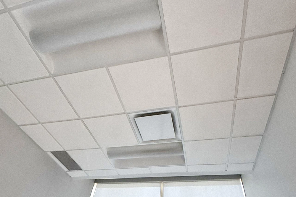 Drop ceiling tiles and lighting panels in a modern office by Express Drywall Services