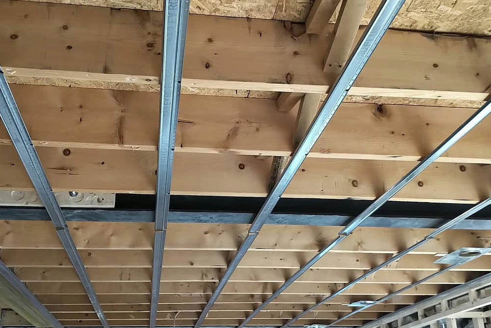 Metal resilient channels installed on commercial ceiling framing in Toronto by Express Drywall Services.