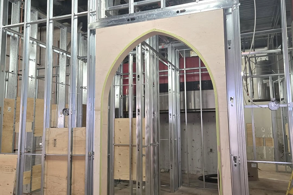Metal framing with a custom arched drywall structure under construction by Express Drywall Services — Commercial Custom Archways and Designs in Toronto.