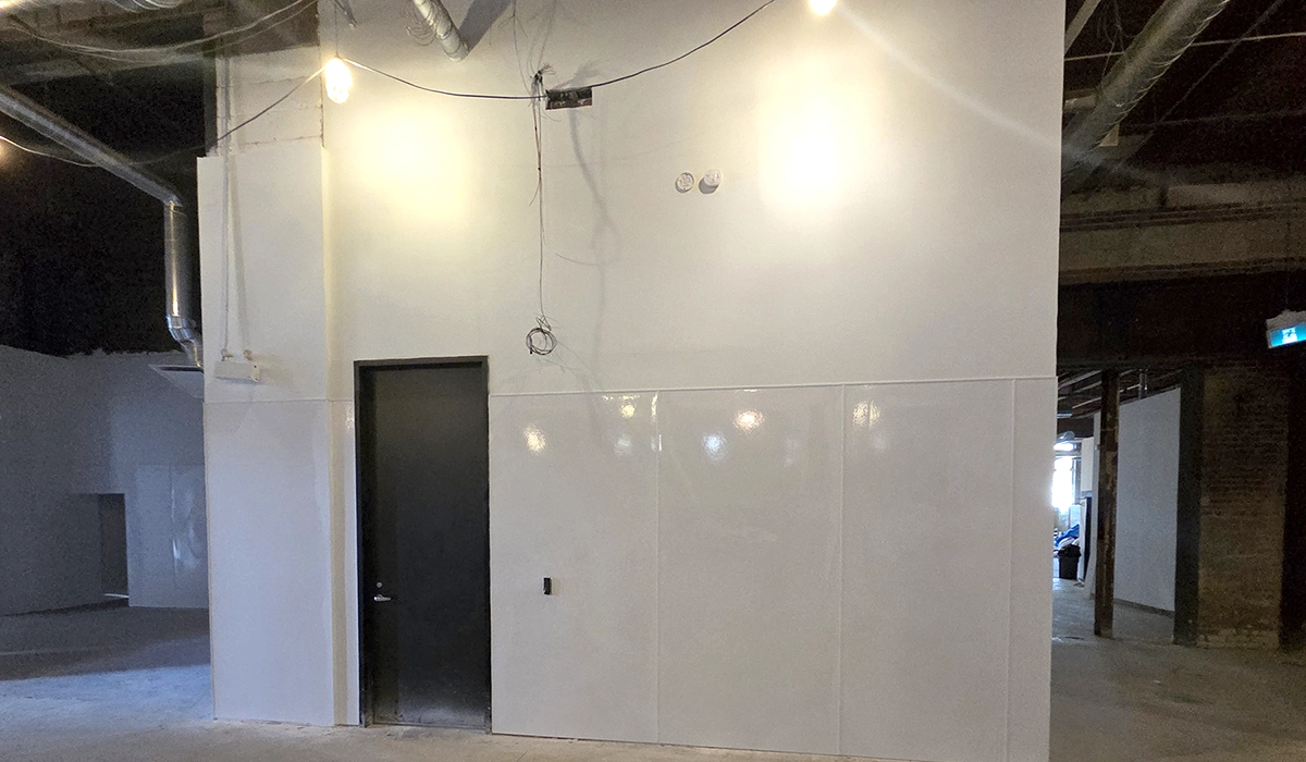 FRP Installation in Toronto by Express Drywall Services with a durable wall panel and black door in a commercial facility.