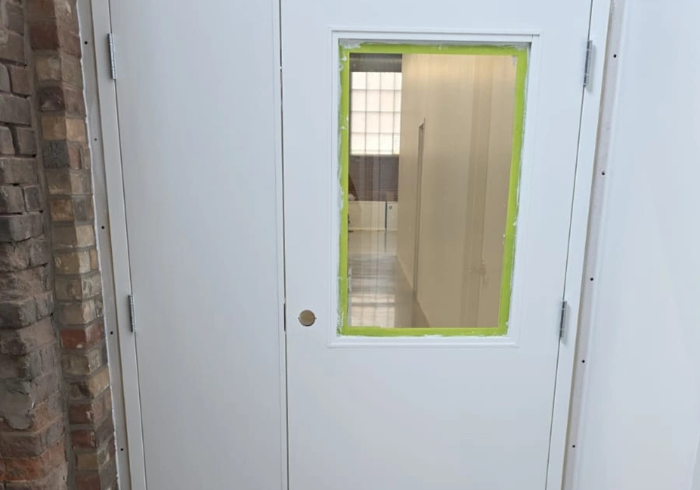 Installed commercial metal door with vision panel by Express Drywall Services in Toronto.