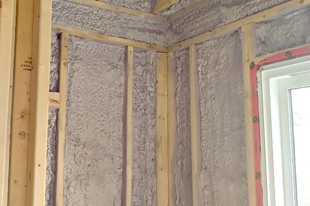 Spray foam insulation applied to wood framing during insulation installation and stickpin insulation in Richmond Hill.