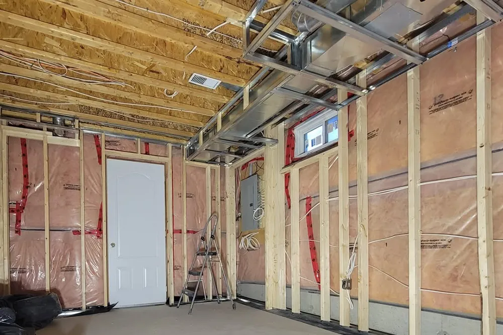 Basement wall with insulation and vapor barrier during insulation installation and stickpin insulation in Richmond Hill.