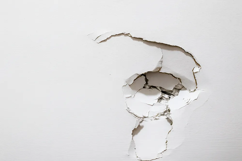 Large hole in drywall before professional commercial drywall repair in Richmond Hill.