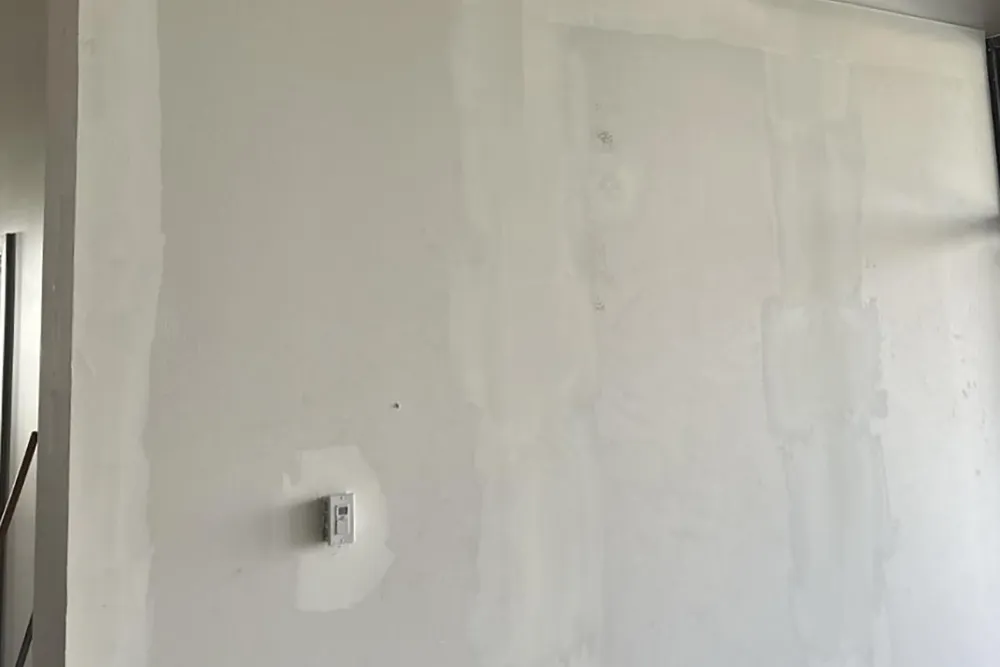 Interior wall with taped joints and applied compound during drywall taping and mudding in Richmond Hill.