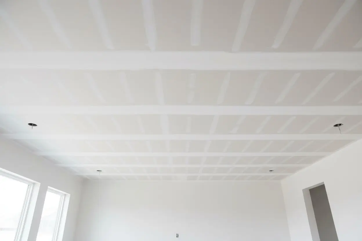 Completed drywall ceiling in Barrie with taped seams and recessed lighting openings.