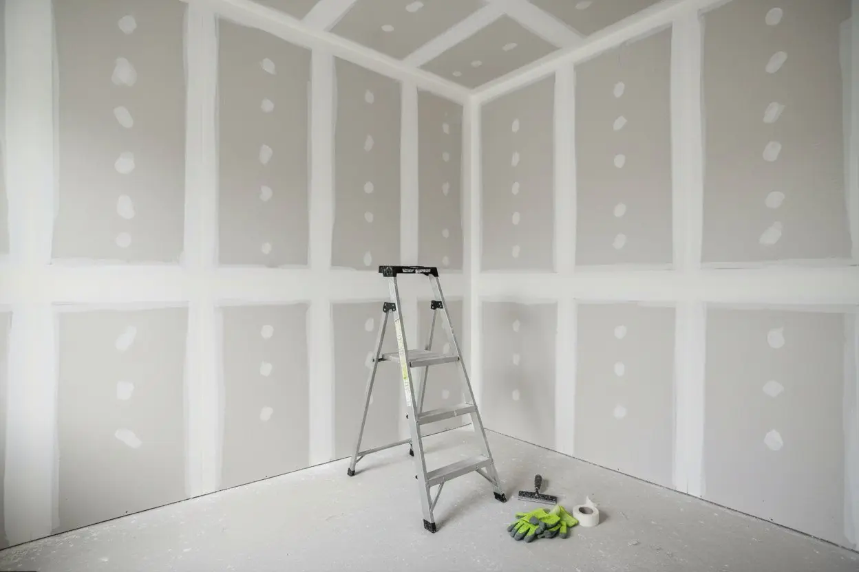 Drywall installation in Tiny Township by Express Drywall Services with ladder, tools and taped joints