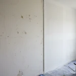 Plaster vs drywall renovation showing old plaster wall replaced by new drywall surface