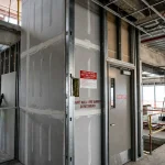 Contractor installing a 2-hour fire-rated shaft wall assembly on a commercial construction site in Ontario